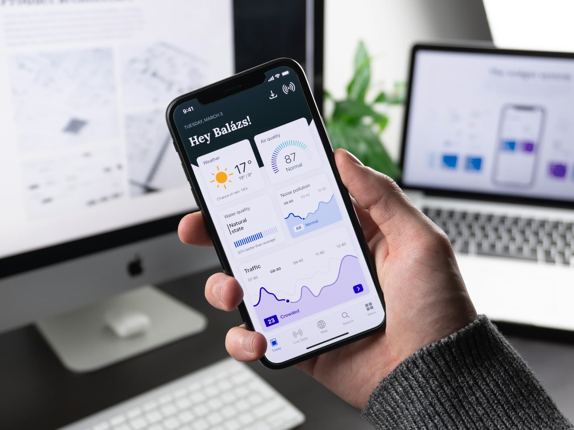 Hand holding a smartphone with an app dashboard