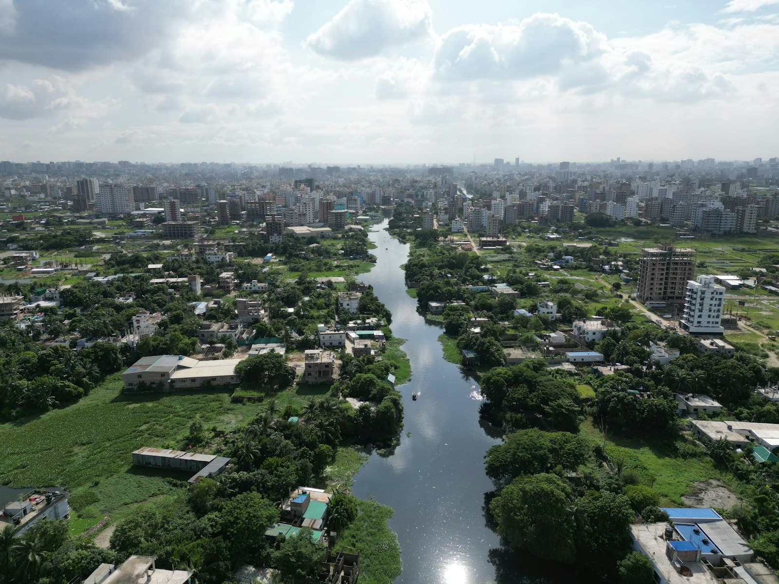 A river winding through green countryside and city in Bangladesh