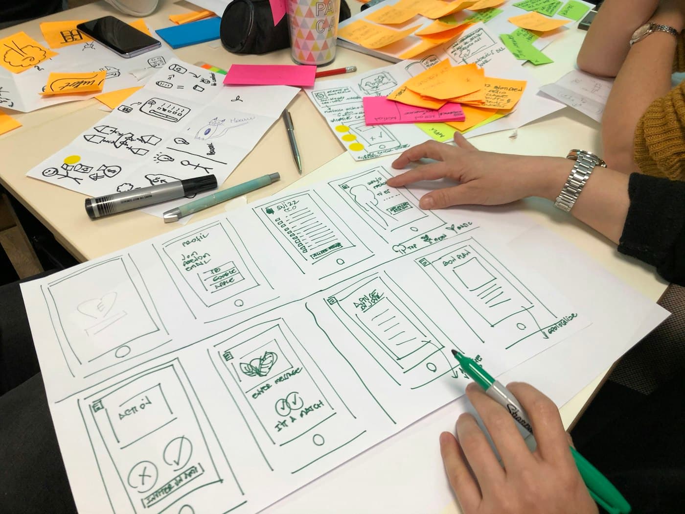 Hands sketching app wireframes on paper