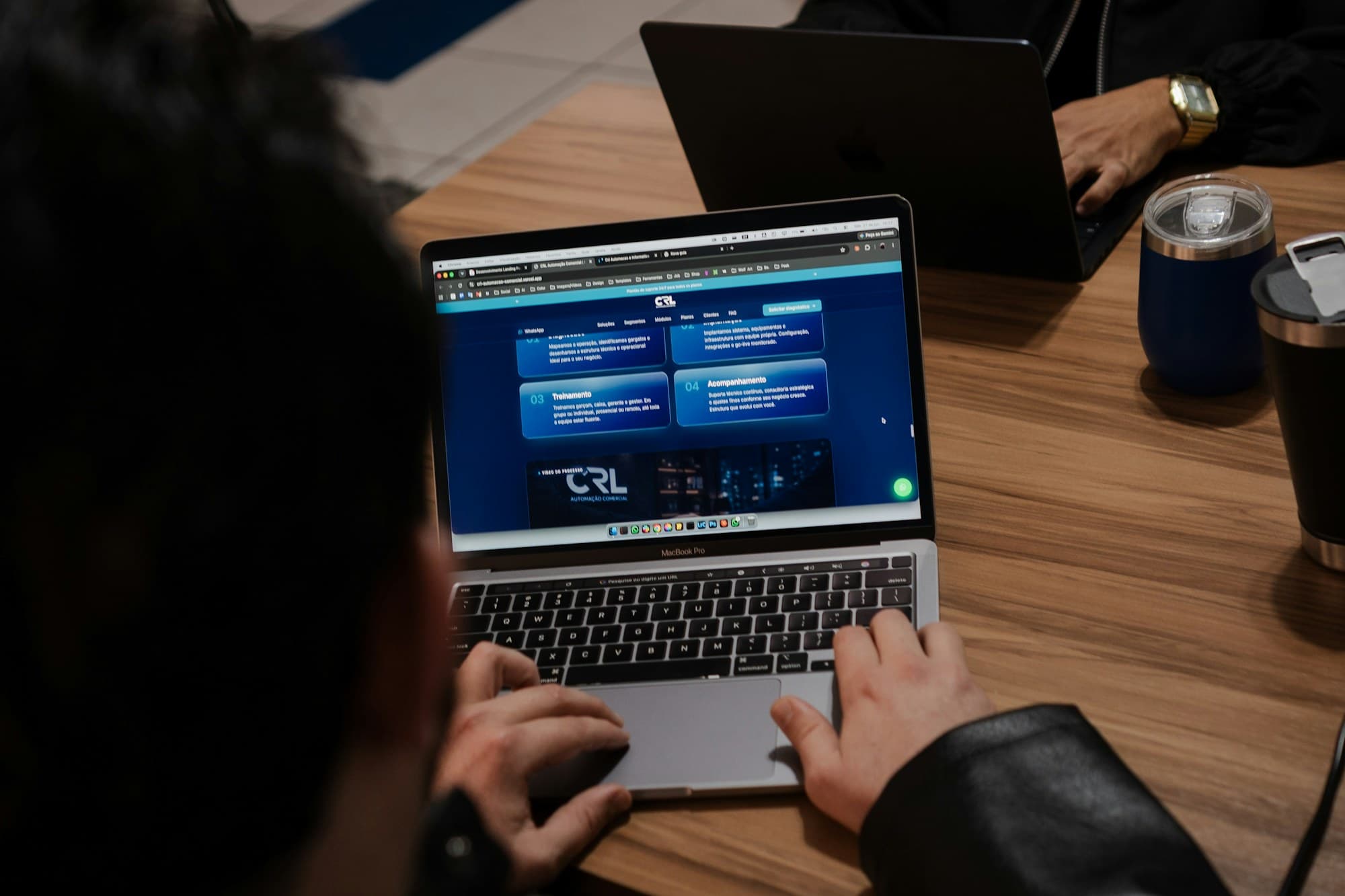 Hands typing on a laptop showing a website